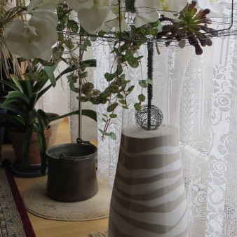 Fausse Orchidée sur un support planté dans un vase avec des strates de sable